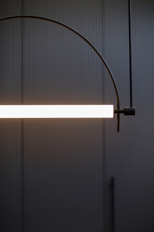 Lampa w formie łuku nad ladą recepcji